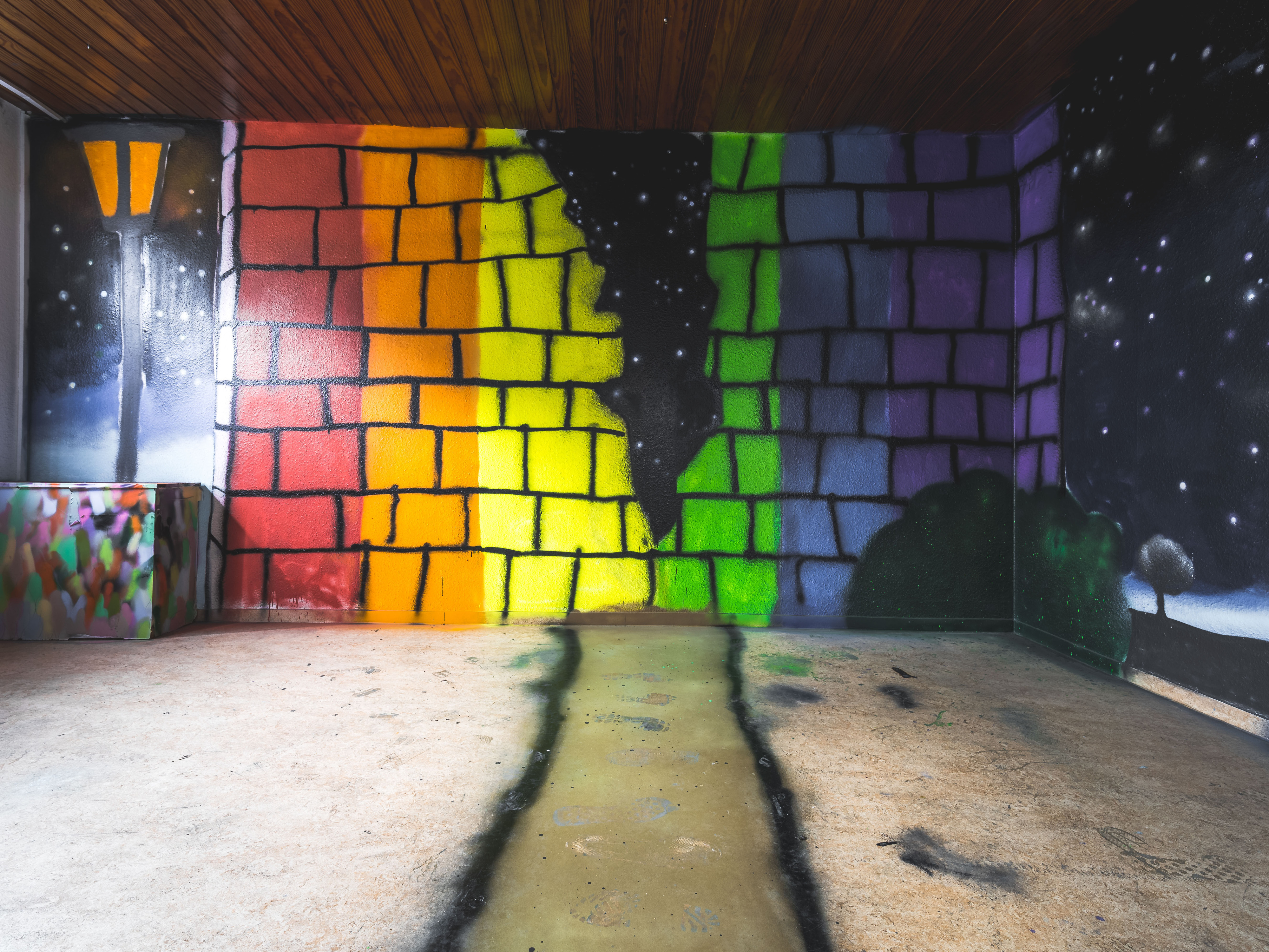 Graffiti-Installation in einem Tunnel mit regenbogenfarbenen Feldern in Blau, Gelb, Grün und Violett