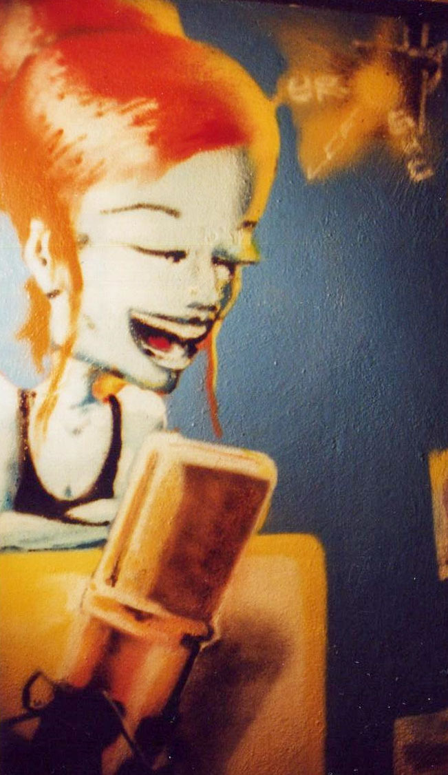 Graffiti einer lachenden rothaarigen Comicfigur mit Mikrofon