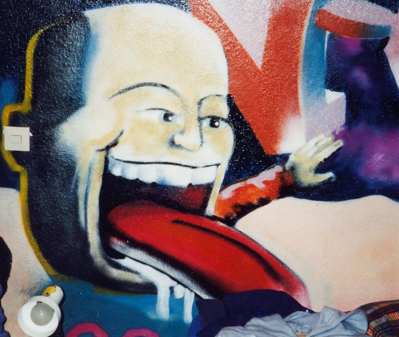 Graffiti eines grinsenden Gesichts in Weiß und Rot mit weiteren comichaften Figuren