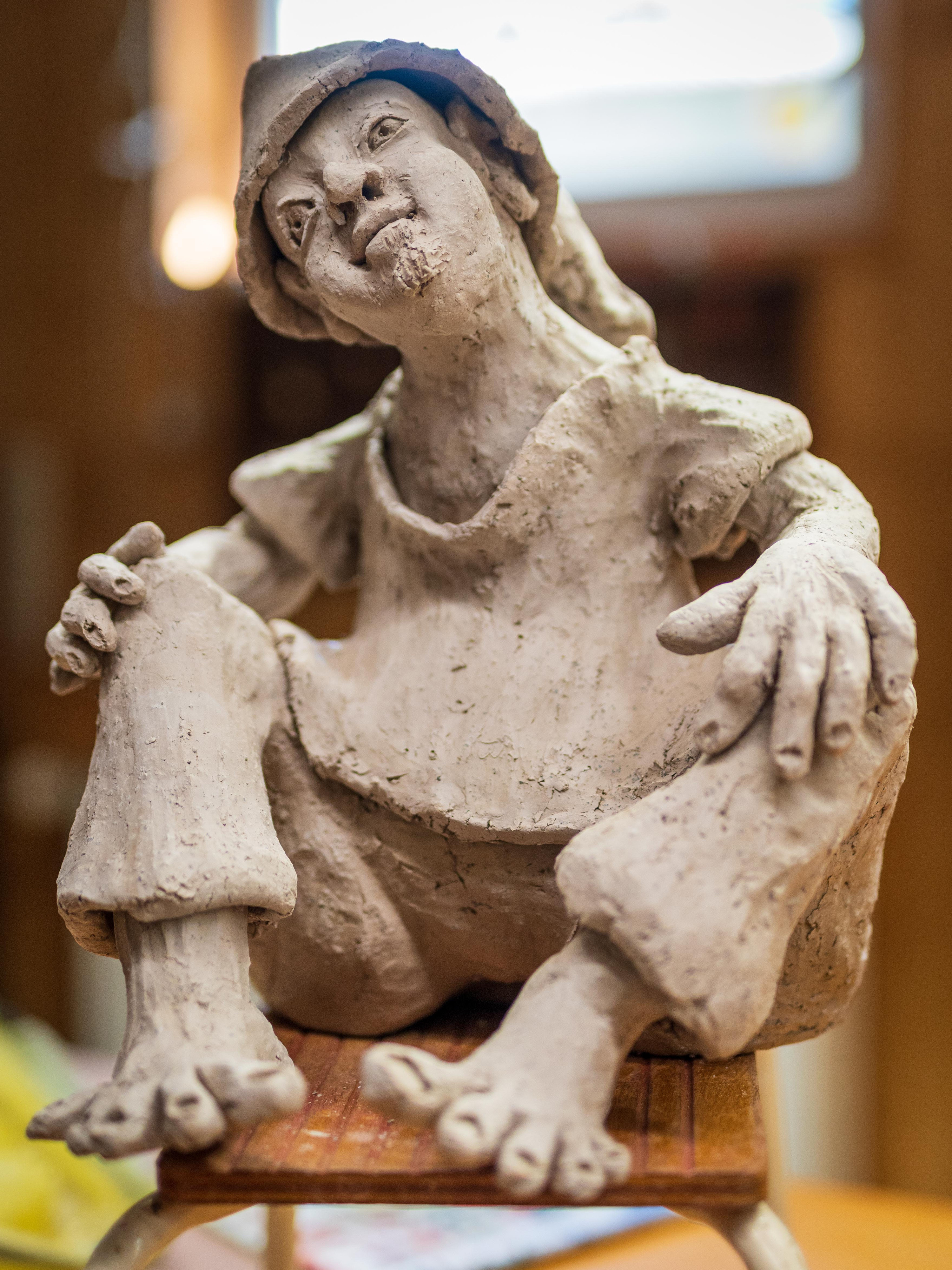 Sitzende Tonfigur mit angezogenen Beinen
