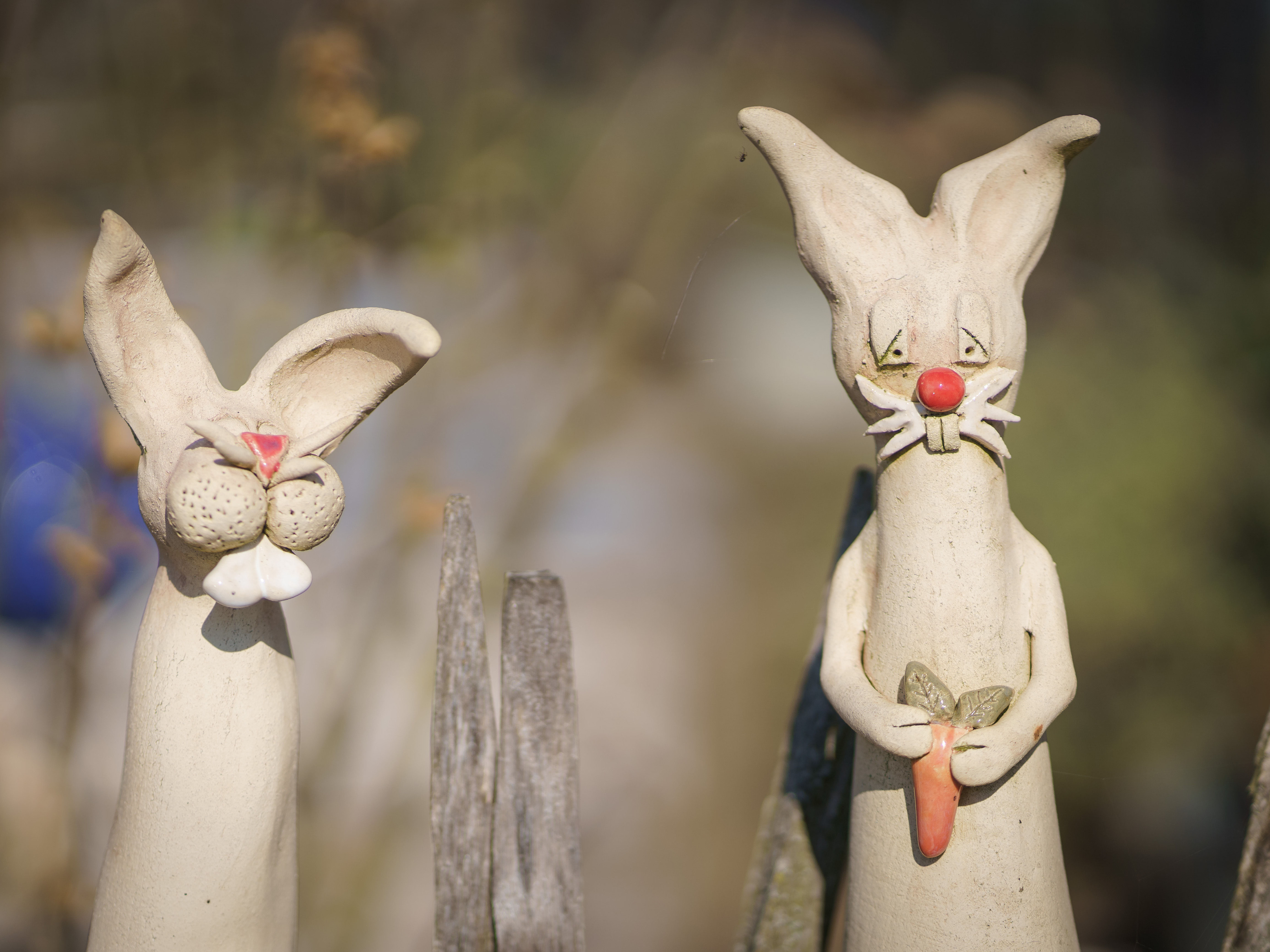 Zwei weiße Hasenfiguren auf Pfosten