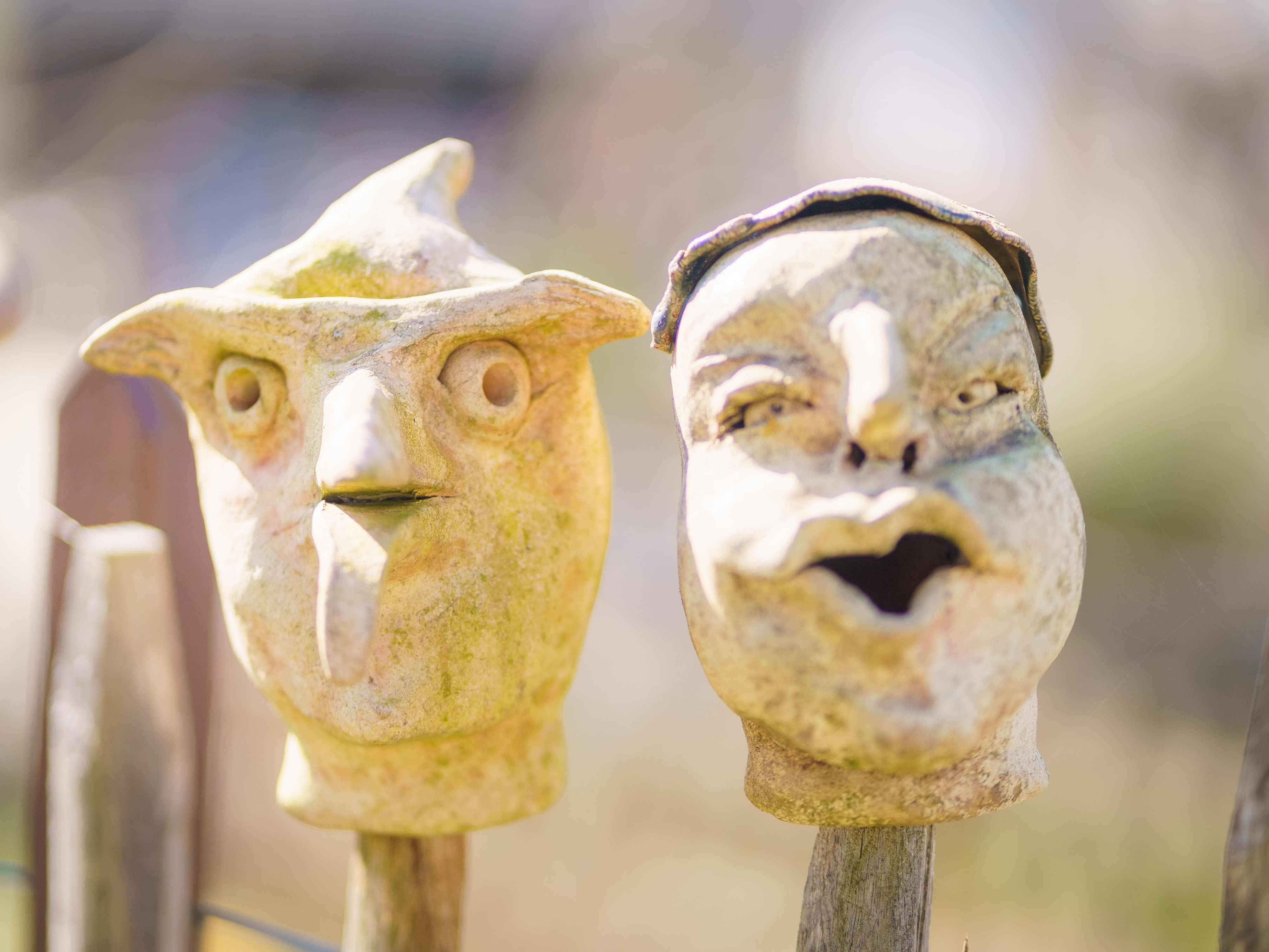 Zwei maskenartige Gesichter im Garten