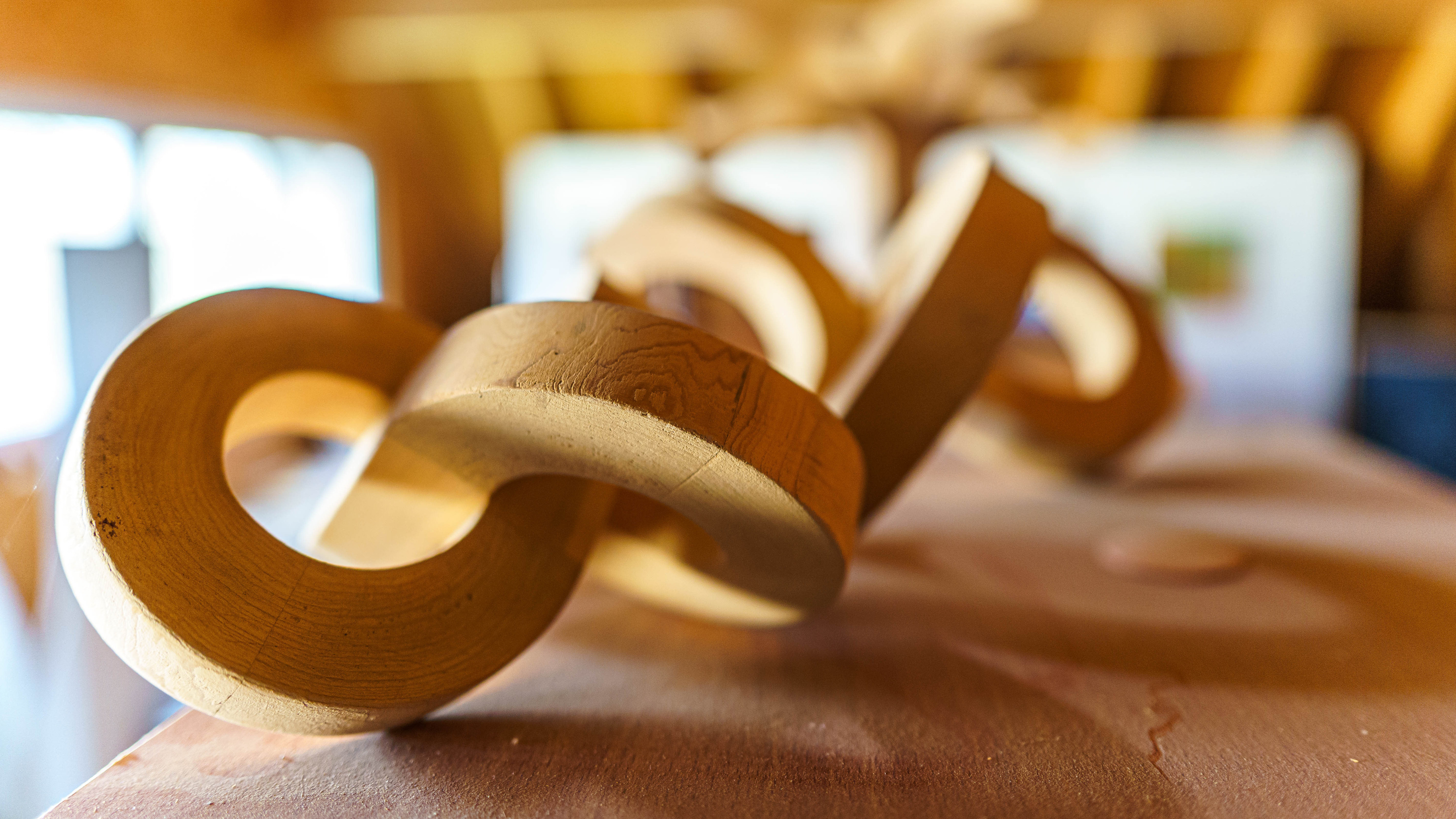 Ineinander verschlungene, ringförmige Holzskulptur