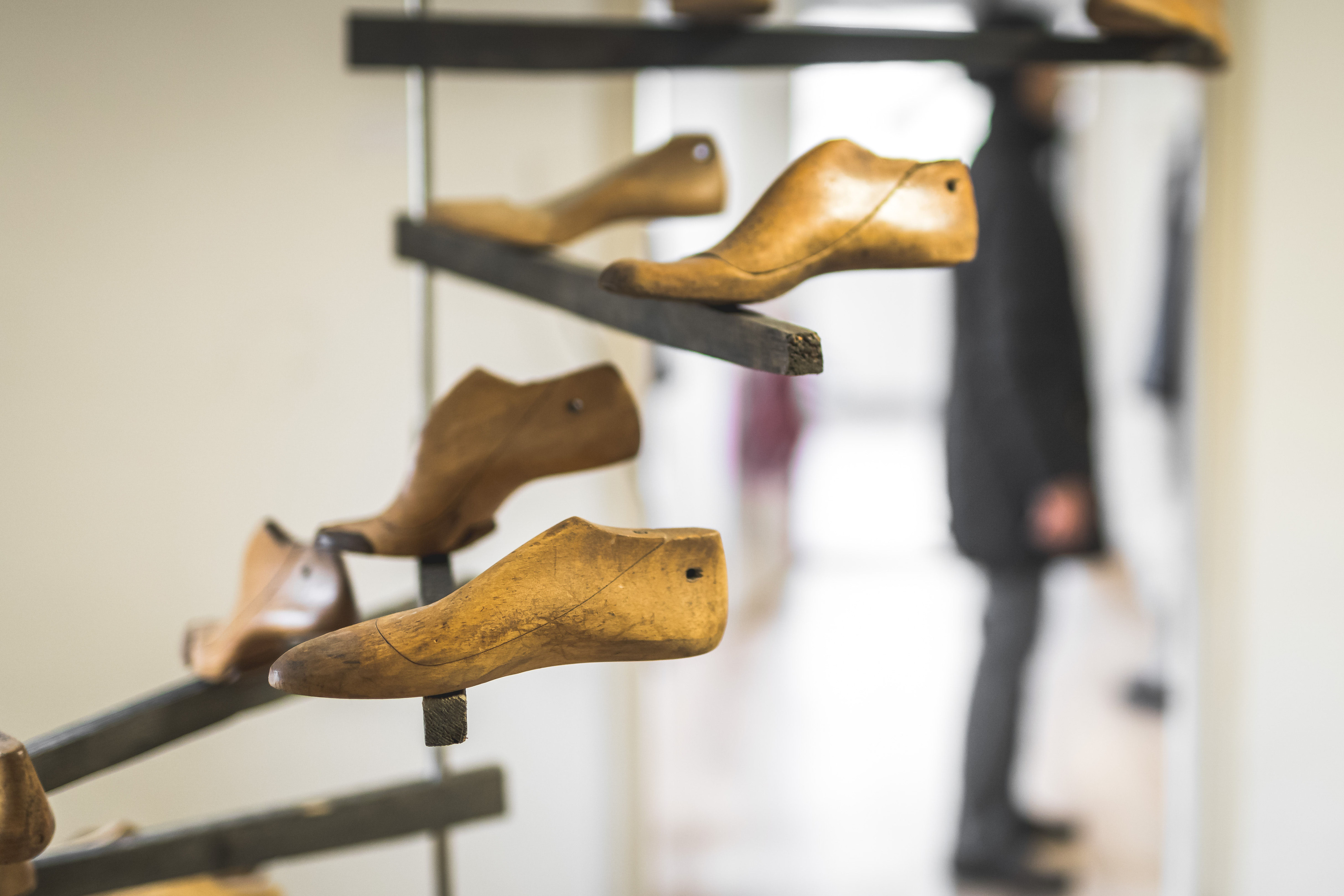 Reihe hölzerner Schuhleisten auf einem Metallgestell