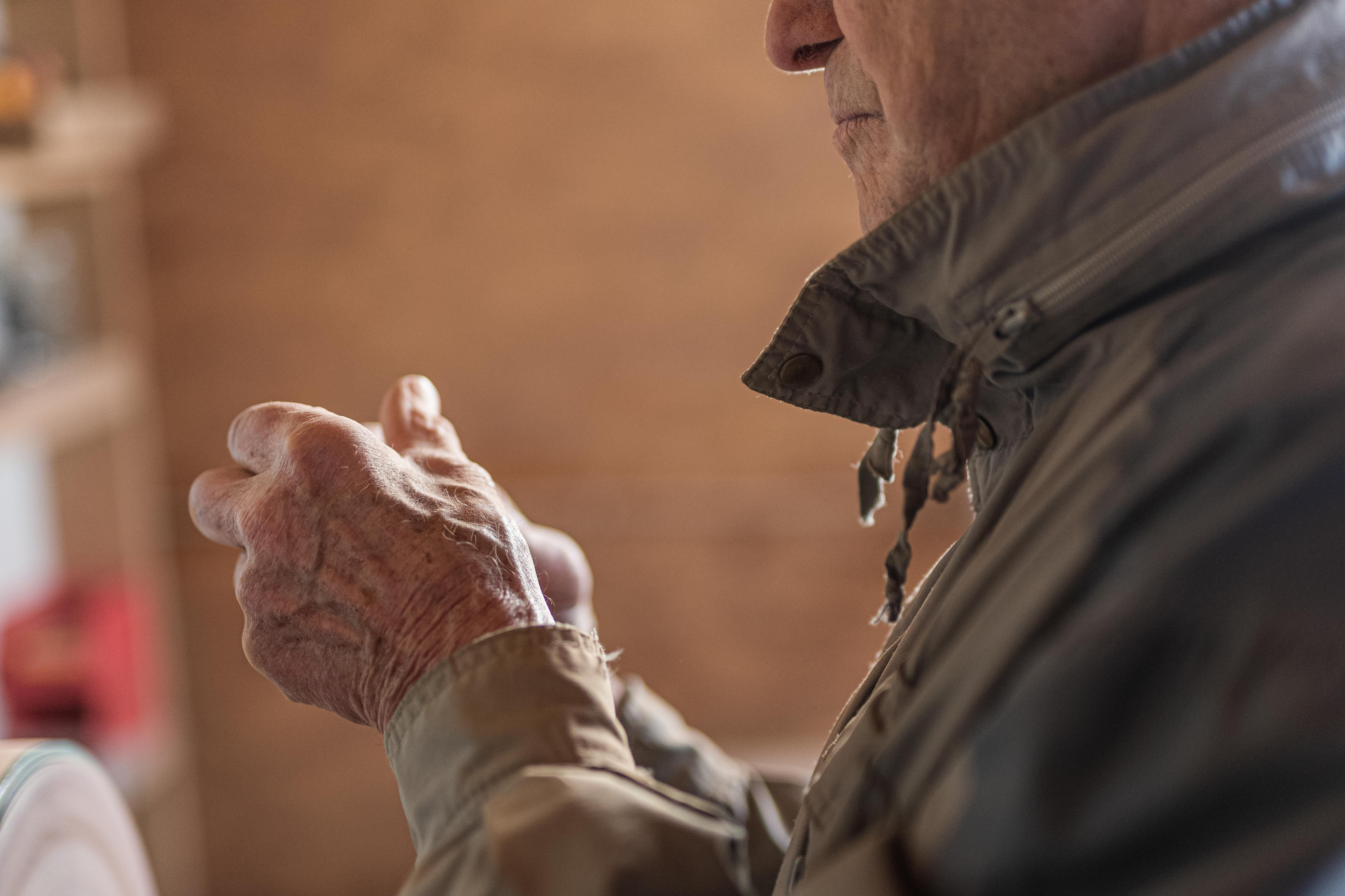 Der Künstler im Profil mit gefalteten Händen