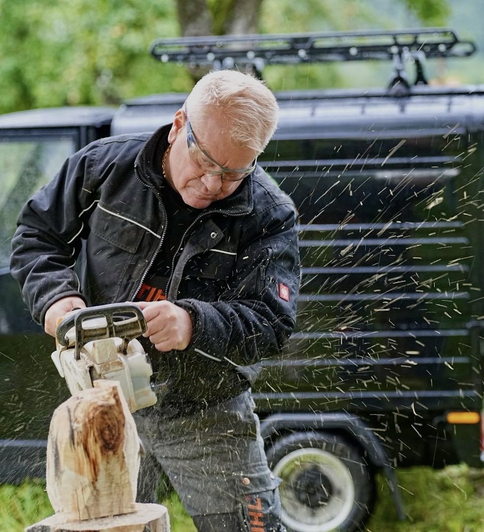 Klaus Braun bei der Arbeit mit der Kettensäge, Späne fliegen umher
