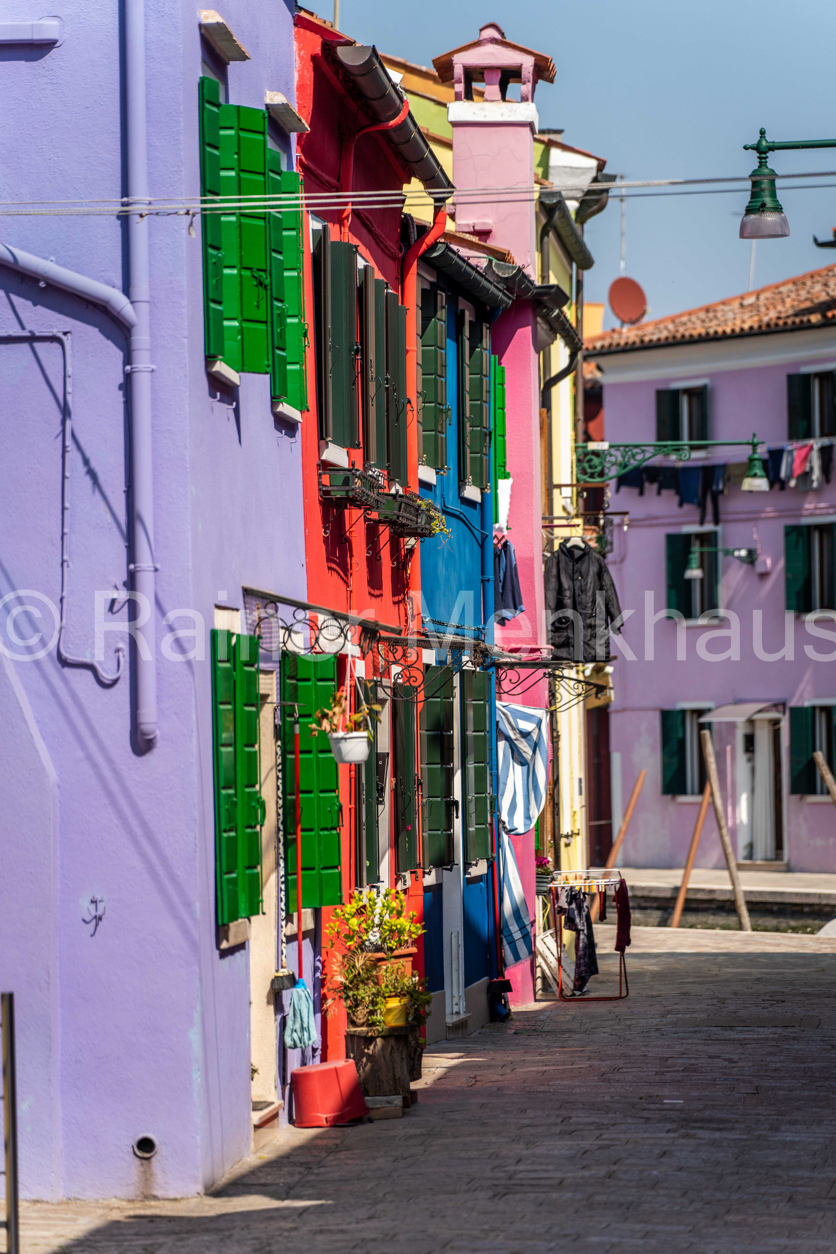 Bunte Häuserzeile in Violett und Grün auf der Insel Burano