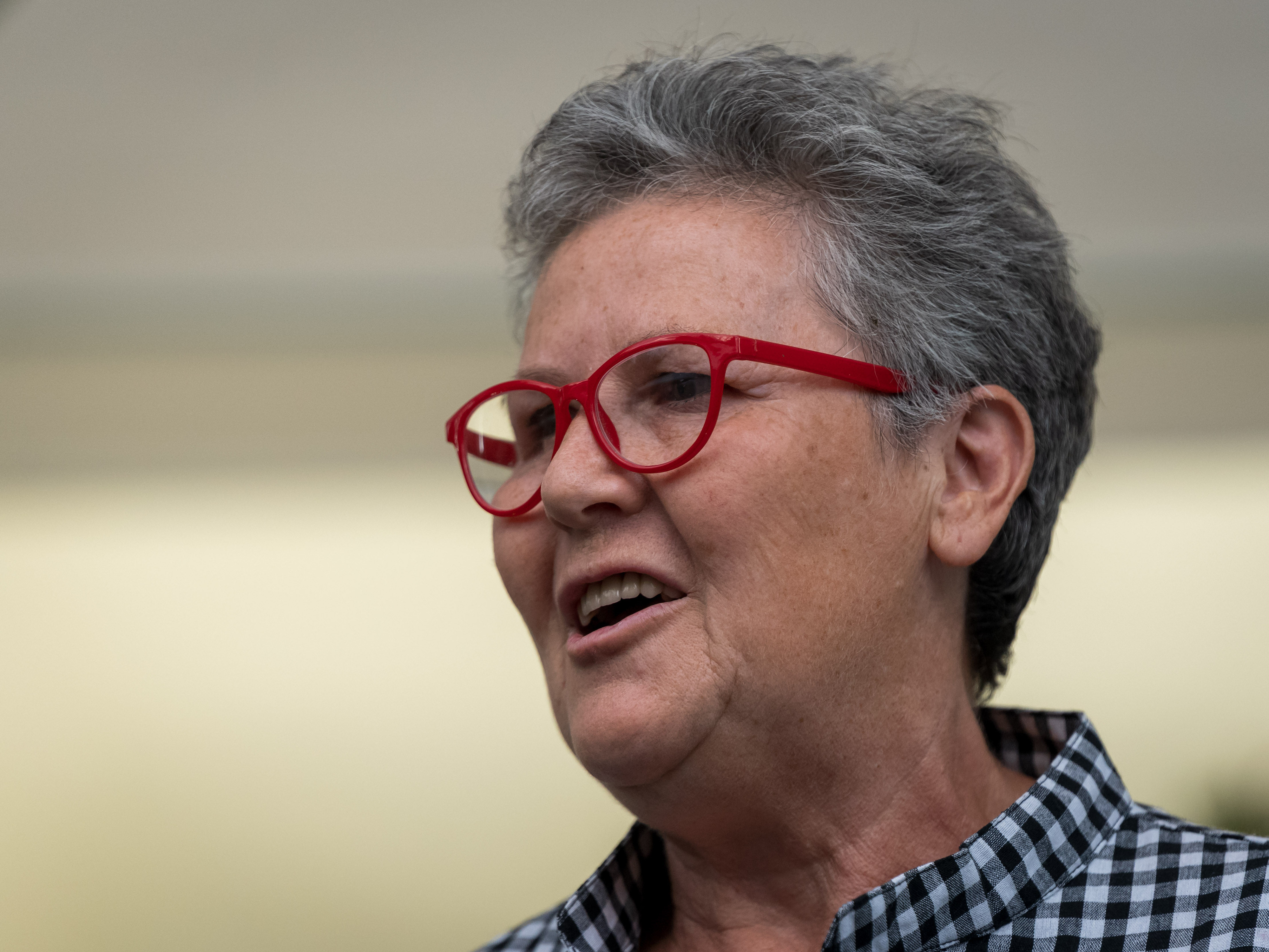 Eine Frau mit roter Brille spricht in ein Mikrofon