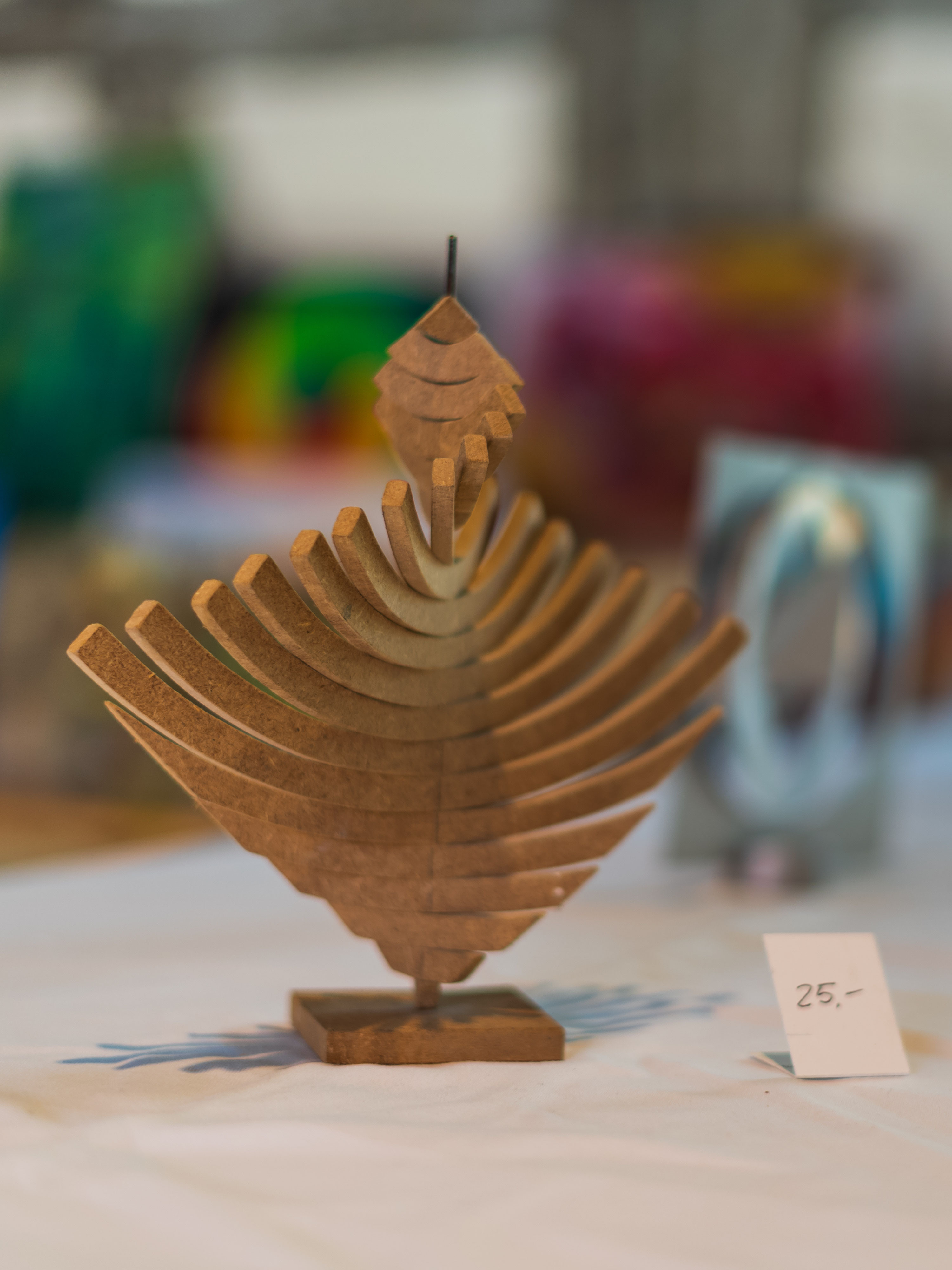 Holzskulptur eines stilisierten Blatts oder Vogels auf einem kleinen Sockel